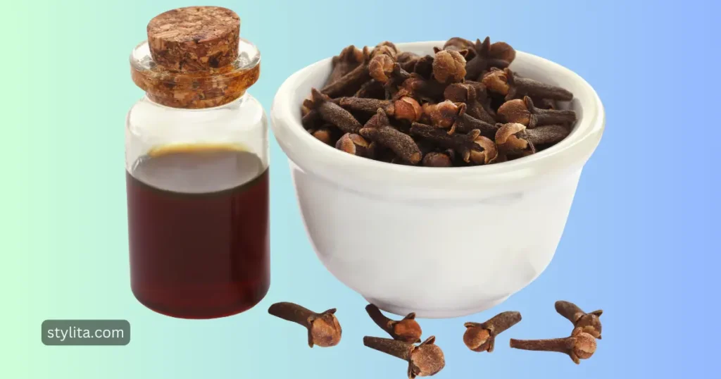 a small bottle filled with clove water is placed by the side of bowls filled with cloves