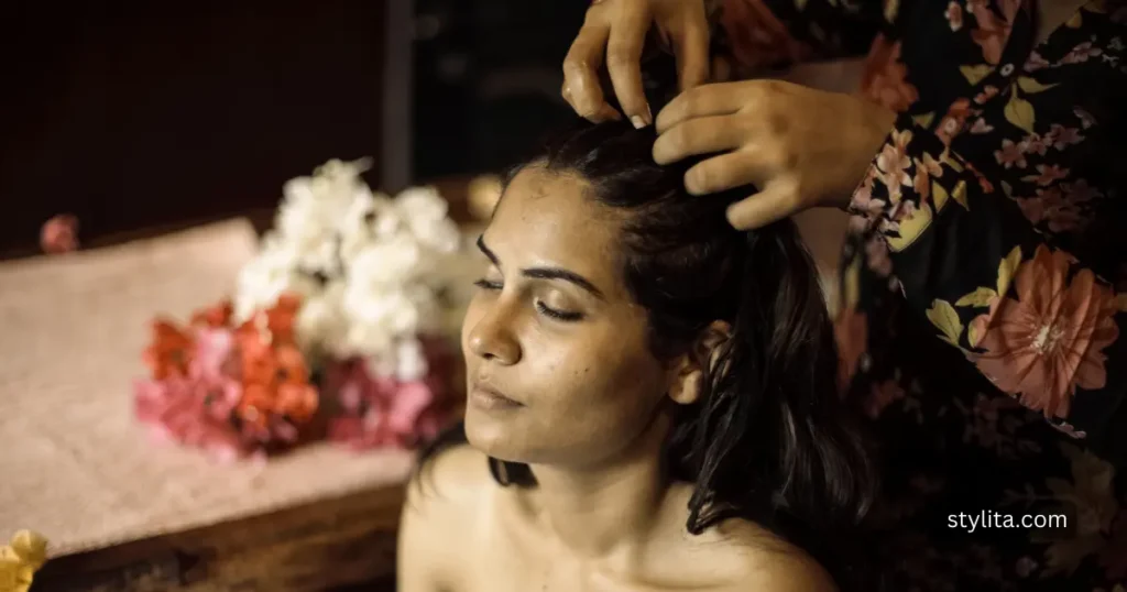a beautiful girl having massage with clove water in her hair at a parlor