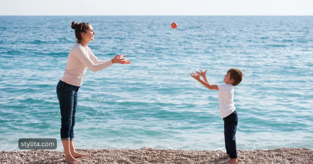 a mother playing with her son on a beach with a ball