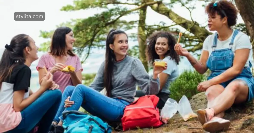 girls enjoying picnic and taking their meal in a happy mood