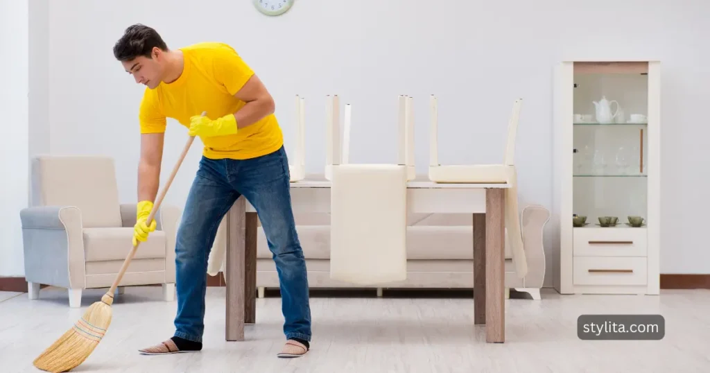 husband cleaning the floor with broom in the absence of his wife