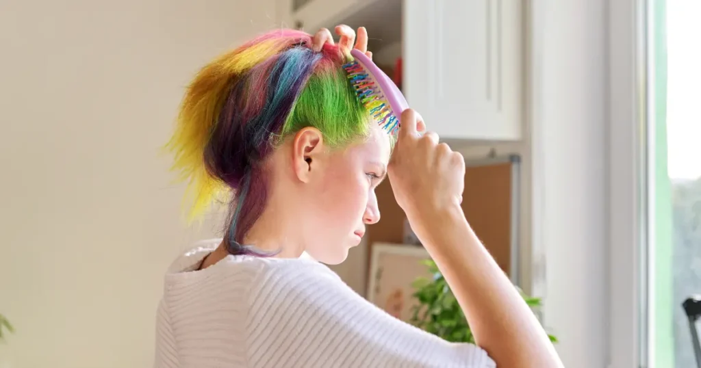 a beautiful girl brushing her multi-color dyed hair