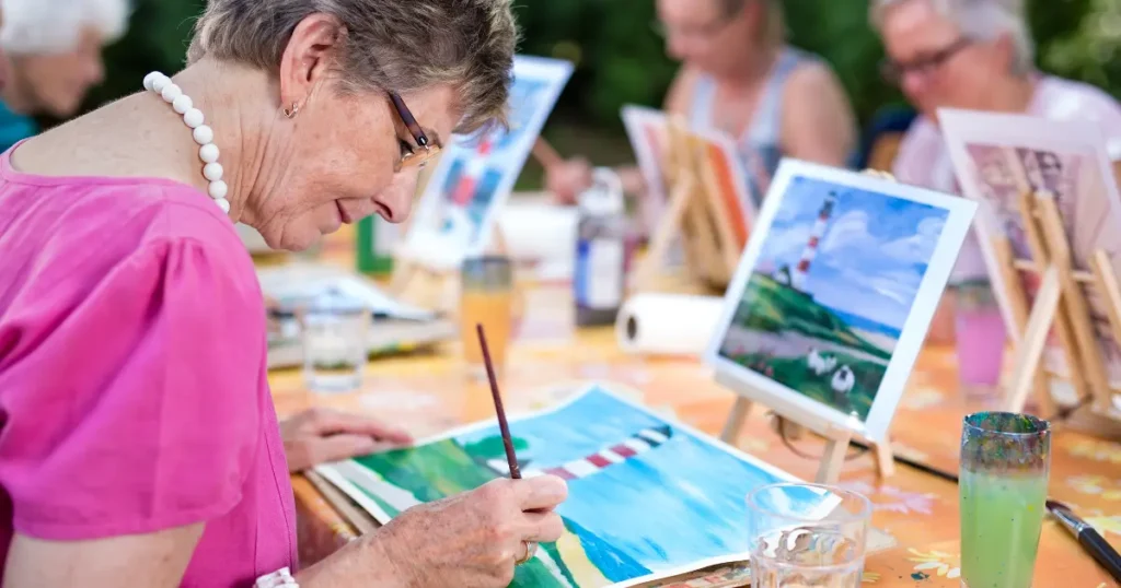 old ladies doing water painting in a group around a table